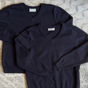 Two navy blue V neck uniform sweaters